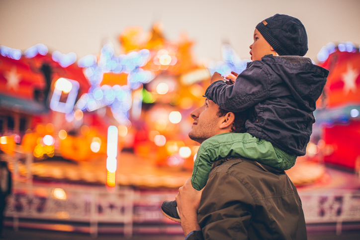 Picture of son sitting on his fathers shoulders at the festival